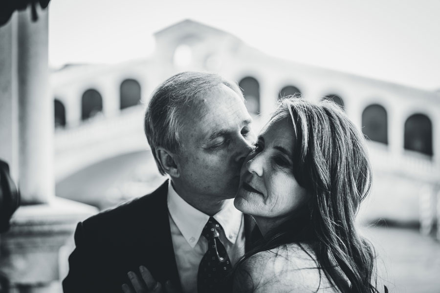 Couple celebrating their anniversary with a romantic photoshoot on a quiet Venetian bridge at sunrise, captured by a local Venice photographer.