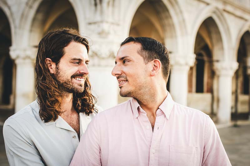 Spontaneous moment of an LGBTQ+ couple having fun during their engagement session in Venice.