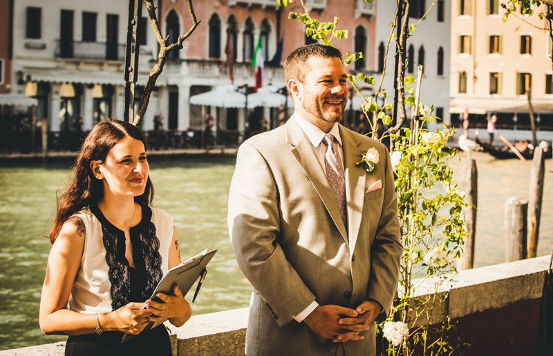 The groom puts on his jacket in a beautifully decorated room, captured by their venice elopement photographer.