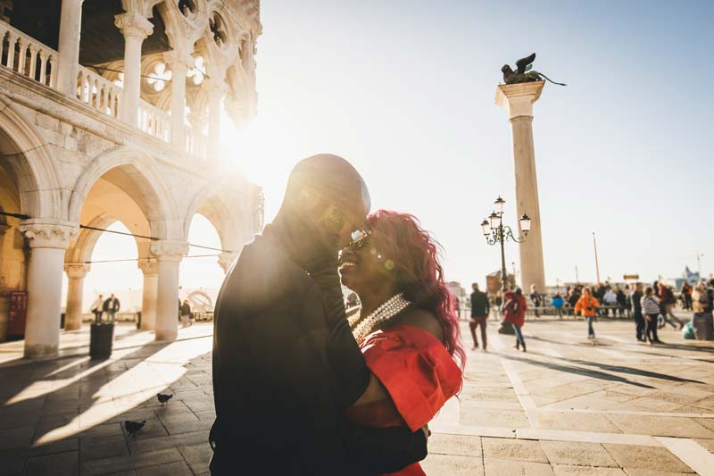 A silhouette of the couple against the golden light of a Venetian sunrise, captured during their morning photoshoot.