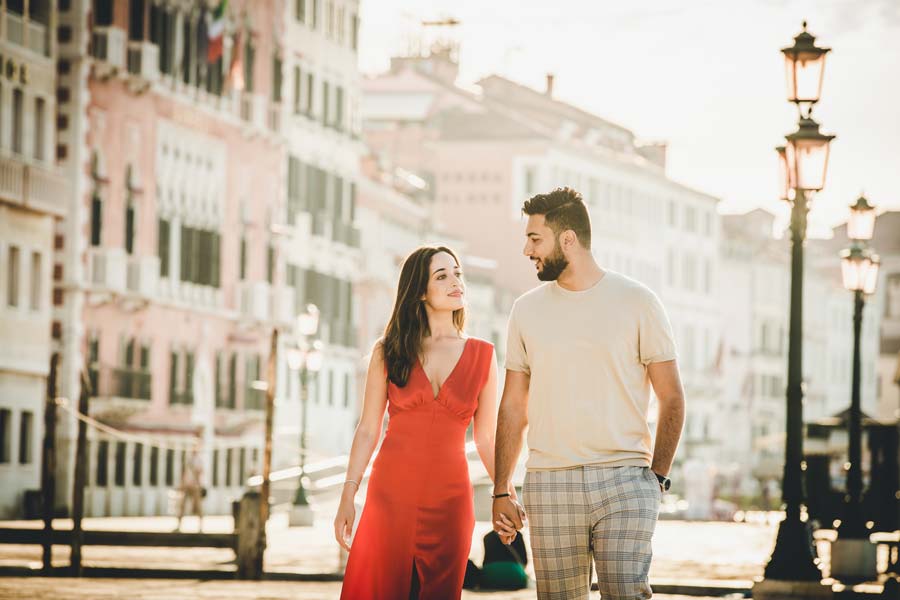 Couple walking along a quiet Venetian canal captured by a Venice vacation photographer at sunrise