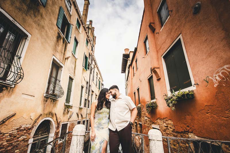 Venice engagement photoshoot with couple kissing on a bridge.