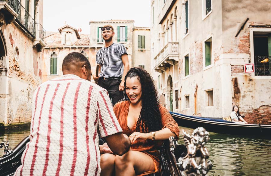 A man down on one knee proposing in a private gondola ride