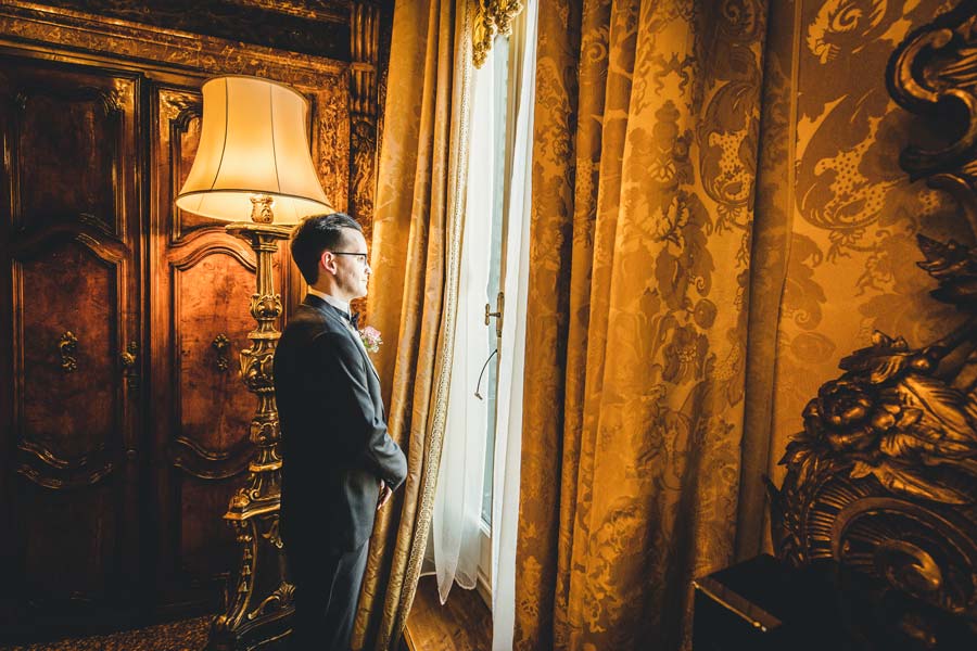 Groom adjusting his cufflinks in a luxurious suite at Hotel Danieli