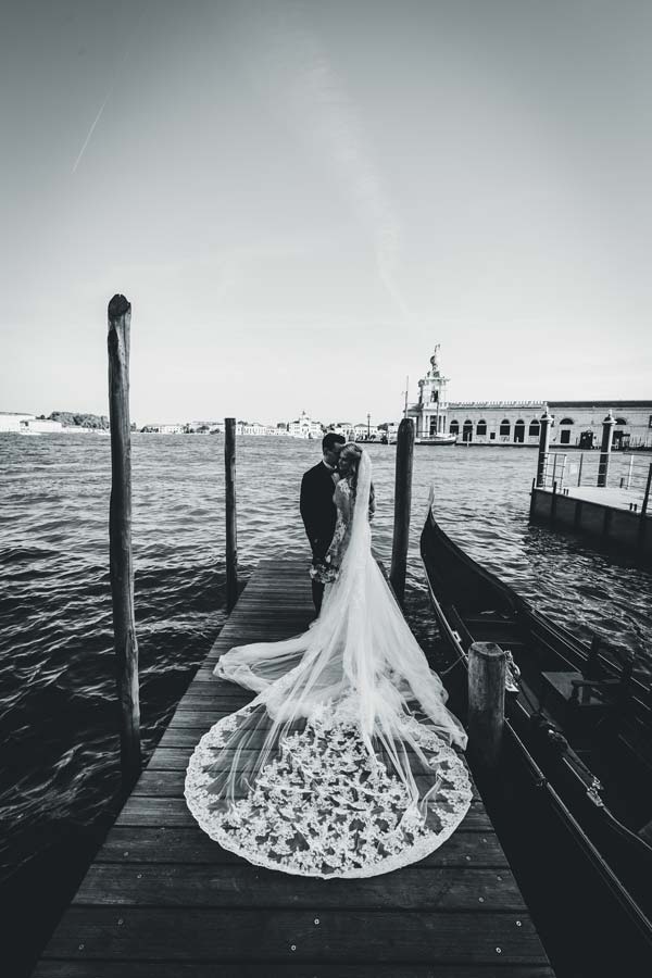 Black and white photo of the couple walking through St. Mark’s Square