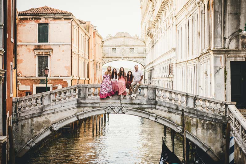 Warm sunrise light illuminating a family in Venice city center
