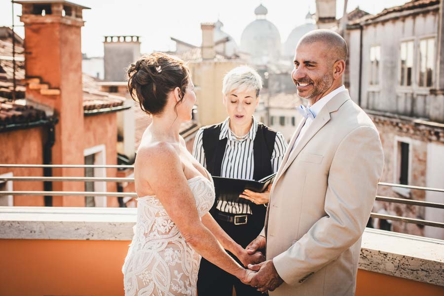 Bride and groom holding hands on a balcony at Hotel Splendid in Venice