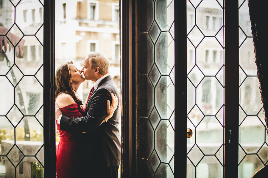 anniversary portrait of a couple walking through hidden alleys in Venice during a golden hour photoshoot.