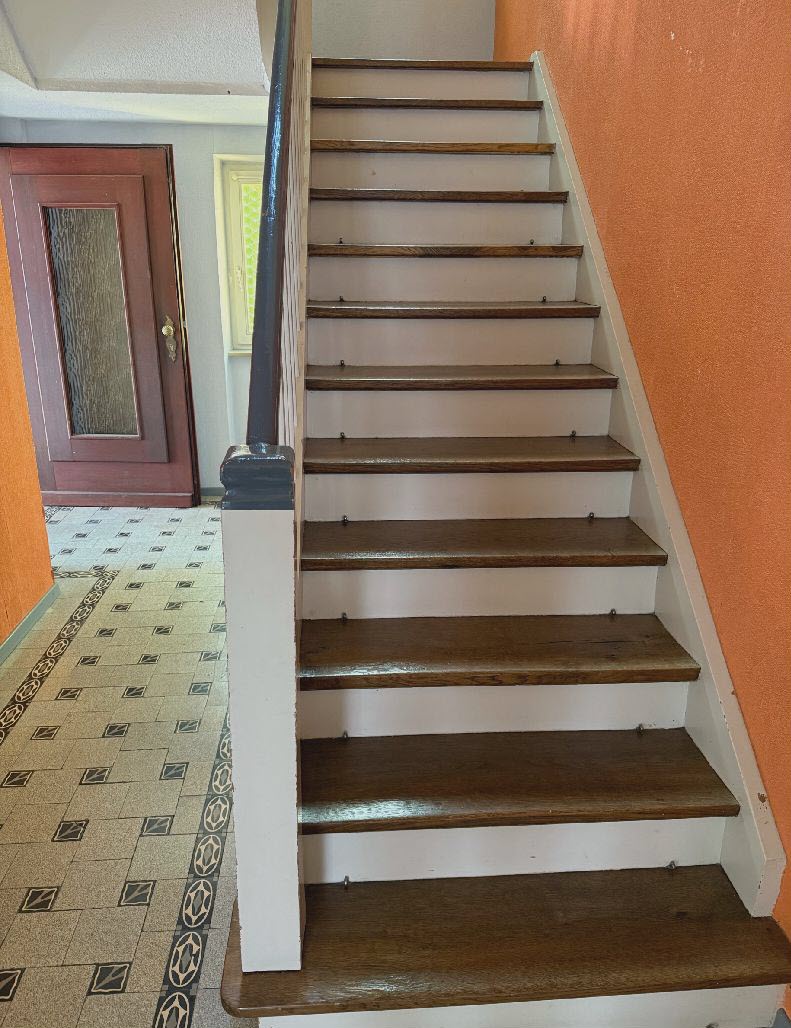 Jugendstil-Fliesen und Eichenholztreppe im Eingangsbereich