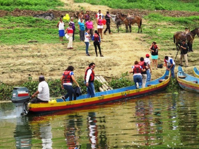 La vicepresidenta del CNE viaja en canoa sobre la represa Poza Honda. Santa Ana, Ecuador.