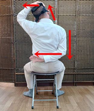 軽く首を左に傾けて左手を頭にのせます。のせた手は左に引くのではなく手の重みだけを感じるようにして下さい。あとは後ろにまわした右手が左方向に、右肩は真下に下げる意識を続けます。