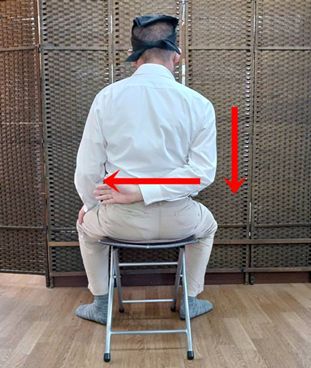 右肩が高い場合は、右肩が下がるようにして右手を後ろにまわします。