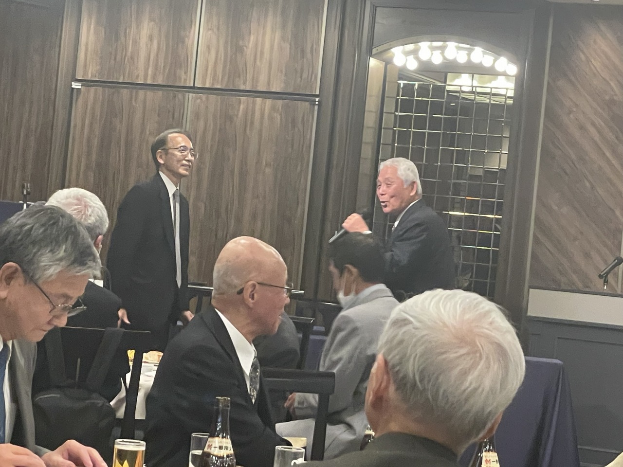 宴もたけなわ、司会に促されて会長が前へ。