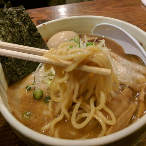 味玉チャーシュー麺を割り箸で食べるところ