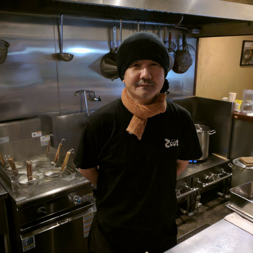 らーめんZoot店主佐藤さん 厨房で黒いTシャツ、黒いタオルを頭にまいている