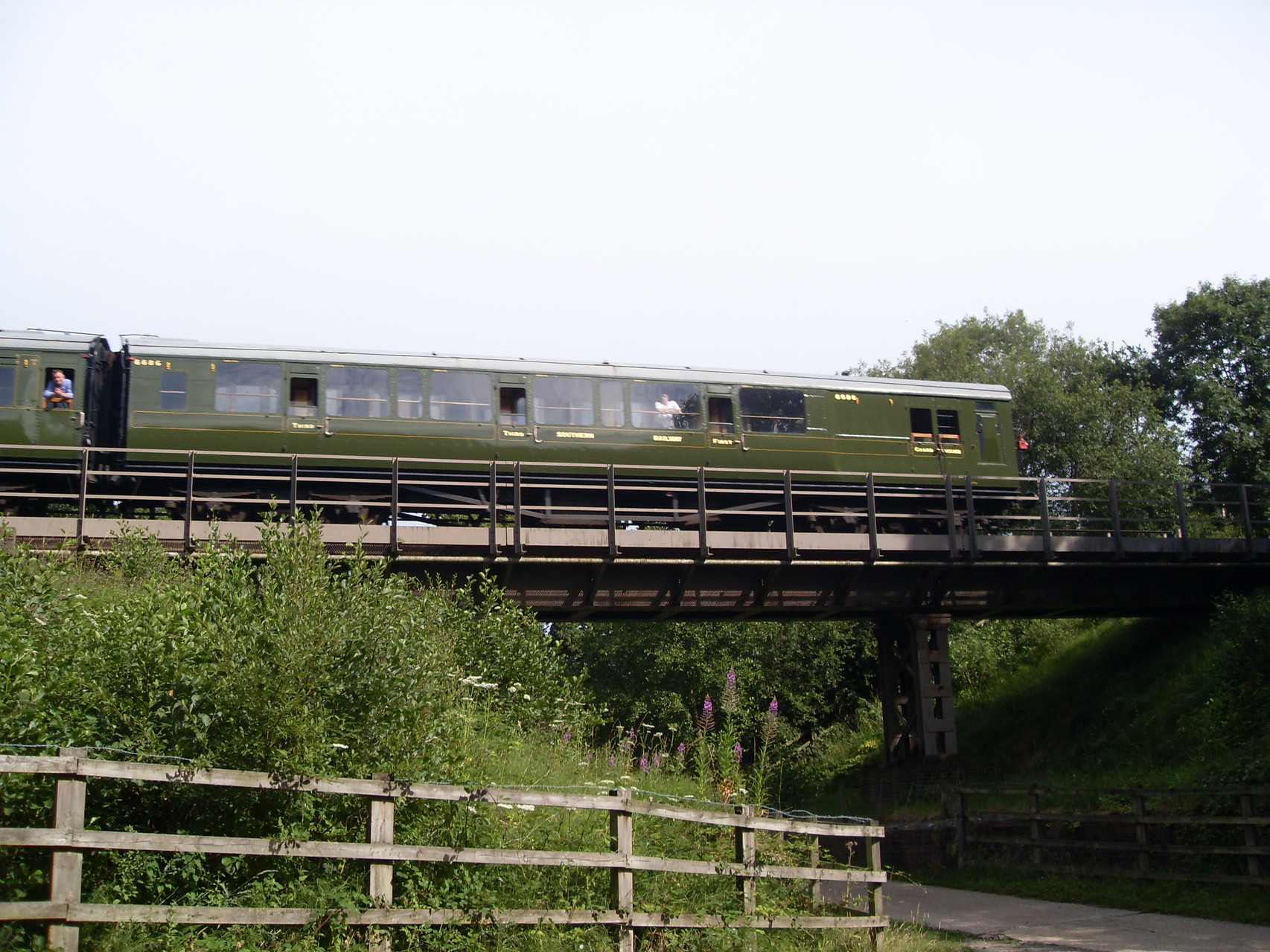 A lovely green steam train on a railway bridge