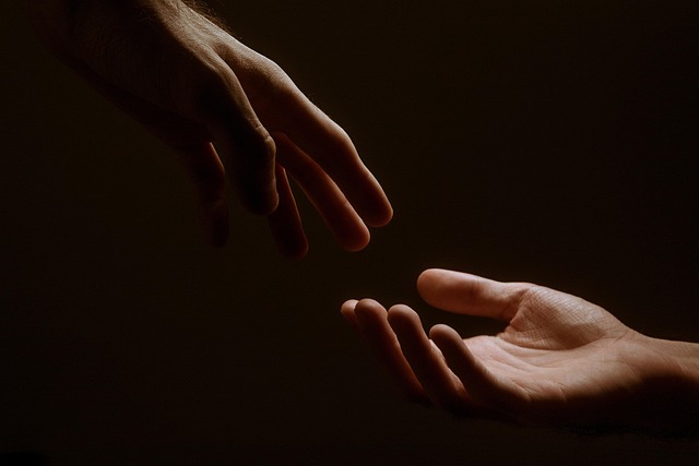 Die Hände zweier Menschen vor dunklem Hintergrund, nur wenig beleuchtet. (Pixabay, lizenzfrei)