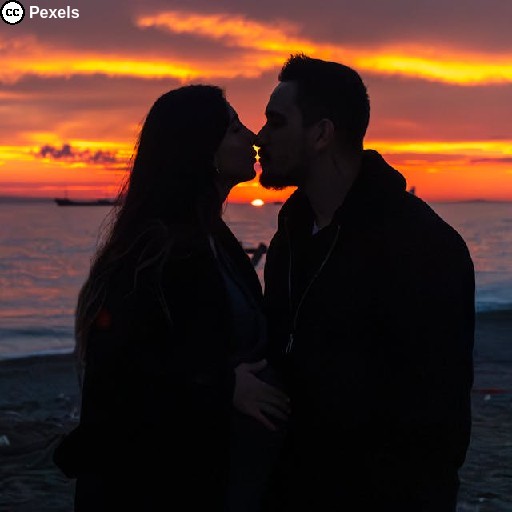 Ein verliebtes Paar küsst sich am Strand bei Sonnenuntergang. Foto von Alimurat Üral auf Pexels.