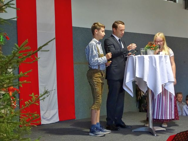 Die Schüler David und Katja und der Moderator Gernot Rohrhofer begrüßen die Ehrengäste 