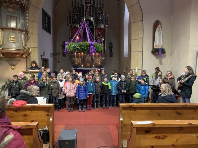 Volksschulkinder der 2., 3. und 4. Klasse singen "Singen wir im Schein der Kerzen"