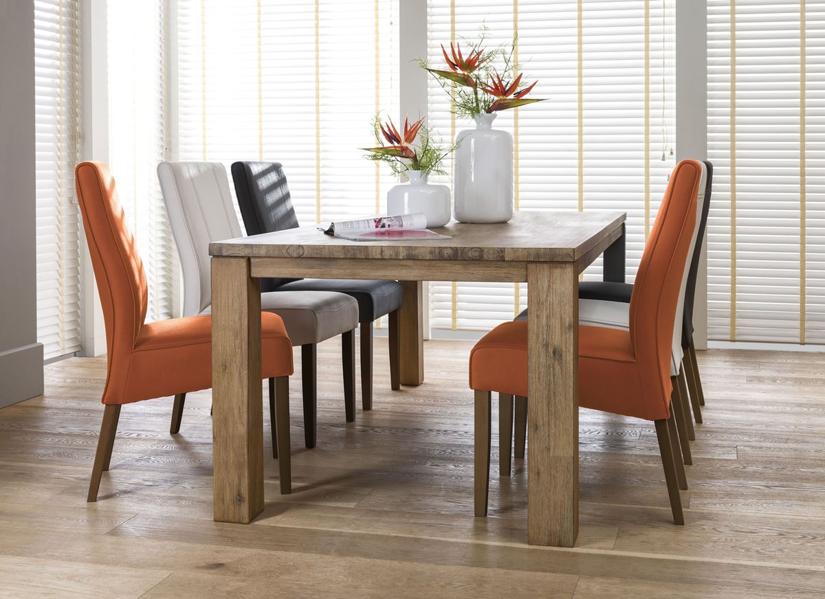 Massiver Holztisch mit orangefarbenen, weißen und schwarzen gepolsterten Stühlen.