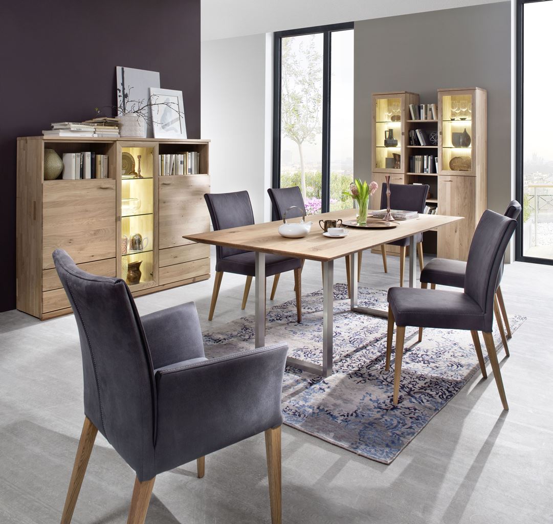 Modernes Esszimmer mit Holztisch, grauen Stühlen und beleuchteten Vitrinen.