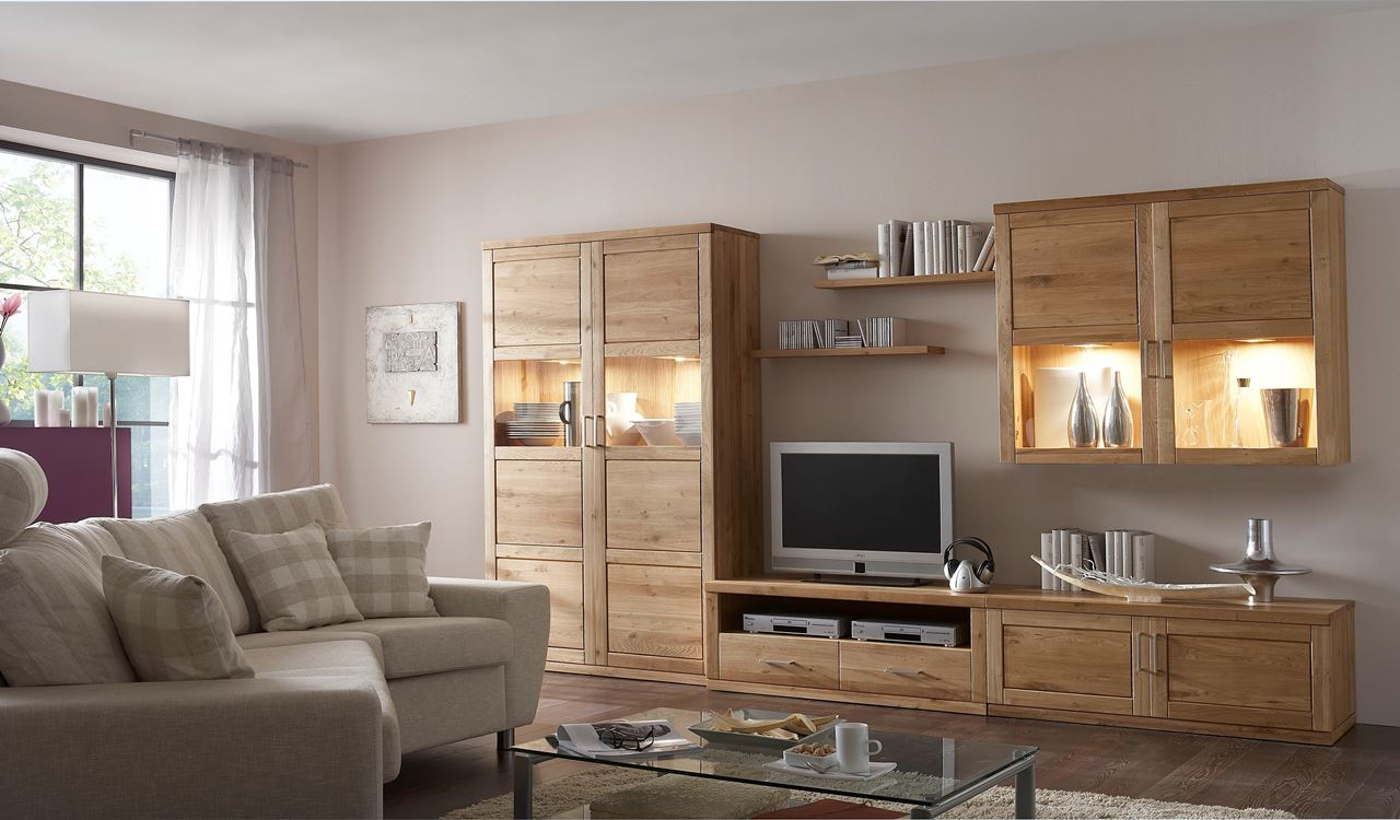 Helles Wohnzimmer mit Regalwand aus Holz und einem grauen Sofa.