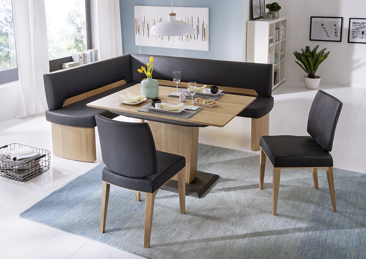 Modernes Esszimmer mit L-förmiger, dunkelgrauer Eckbank und einem Tisch aus hellem Holz.