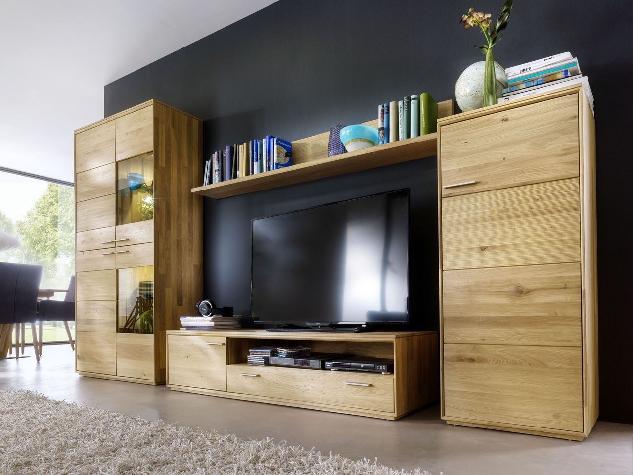 Eine Regalwand aus Holz an einer dunklen Akzentwand.