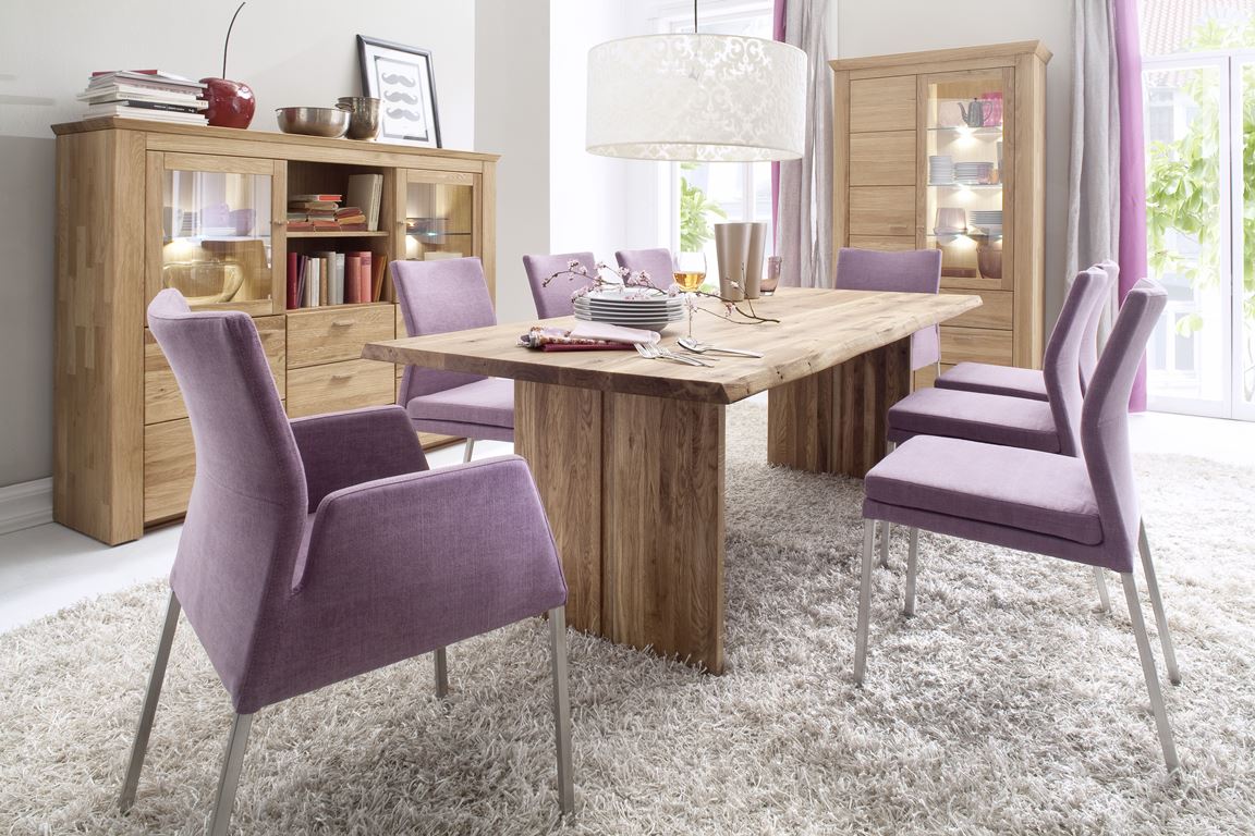 Esszimmer mit rustikalem Holztisch, hellvioletten Stühlen und einem flauschigen Teppich.
