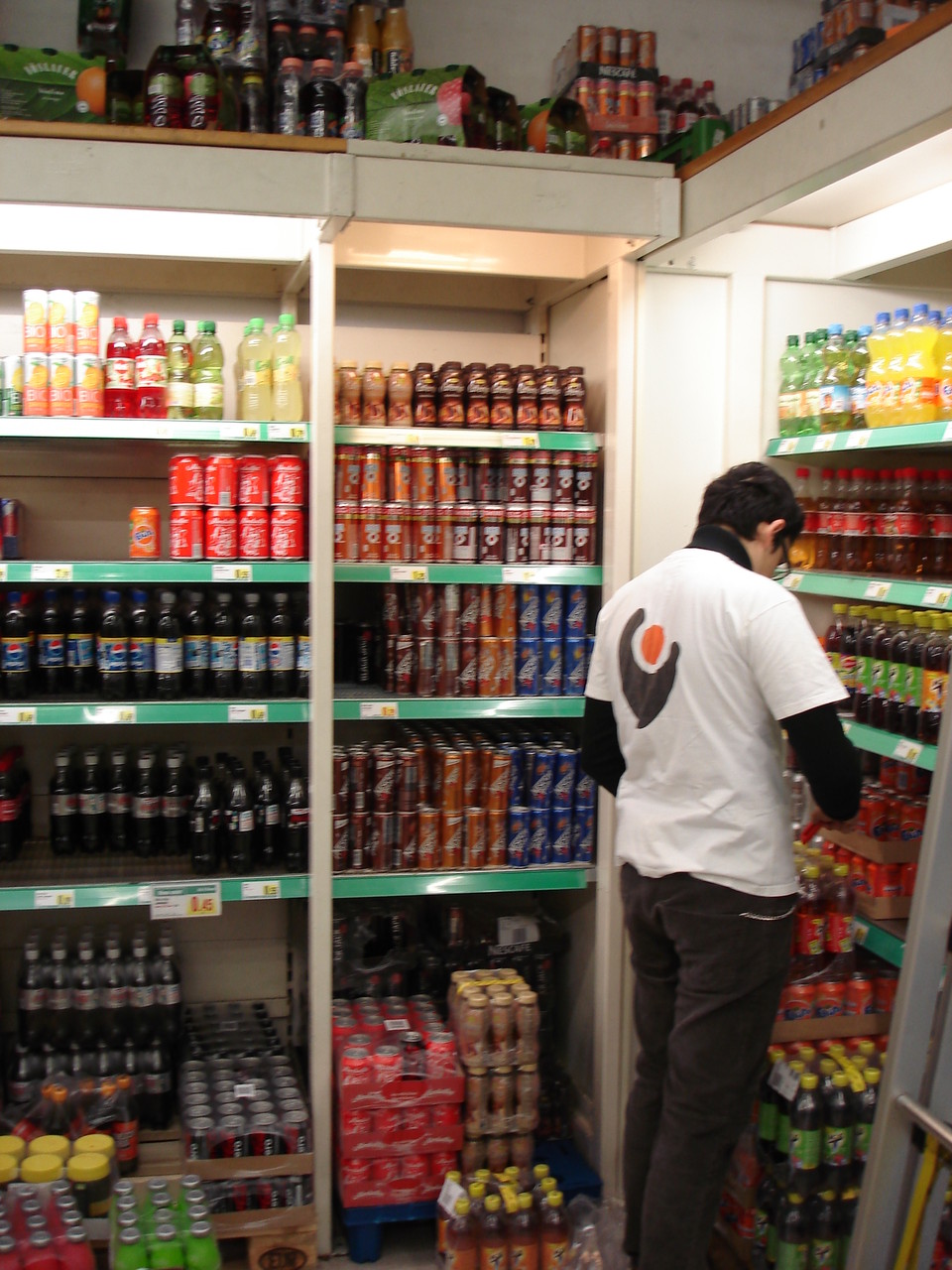Person arbeitet in einem Supermarktregal