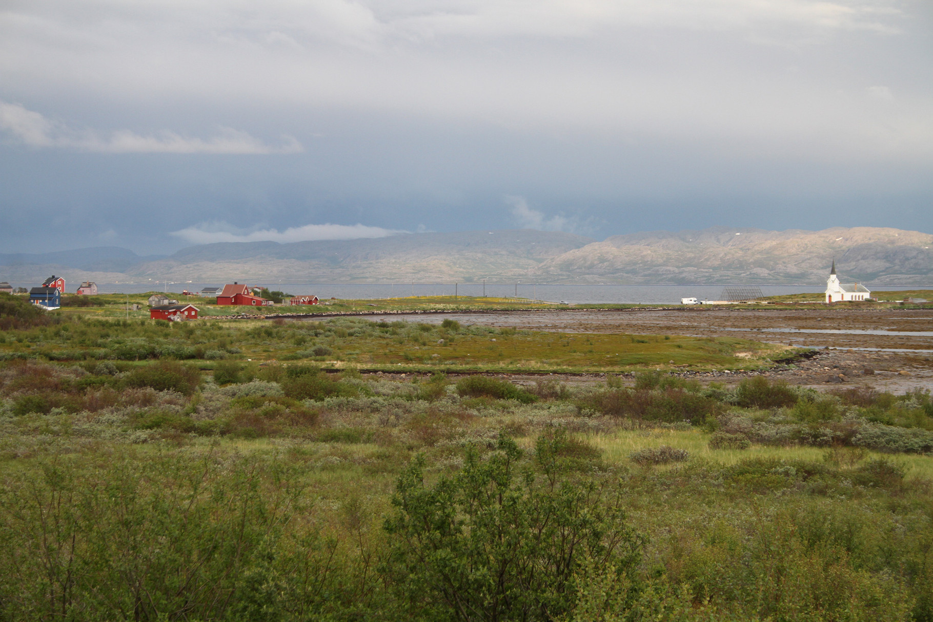 Der Varanger-Fjord mit der Kirche von Nesseby bei einer speziellen Wetterstimmung
