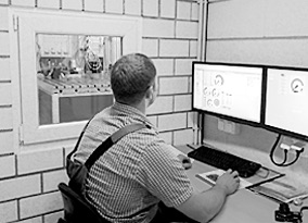 Mann in Arbeitskleidung sitzt vor dem Computer