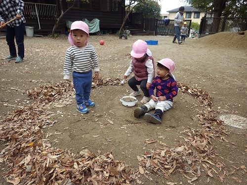 秋あそび「落ち葉で輪っかを作ったら自然と輪っかの中にはいるうさぎぐみ（１歳児）」