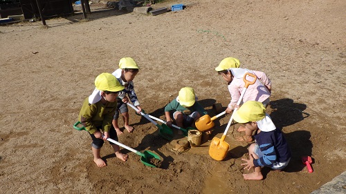 裸足になって川づくり。どうやったらお水が流れるかな？（２歳児）