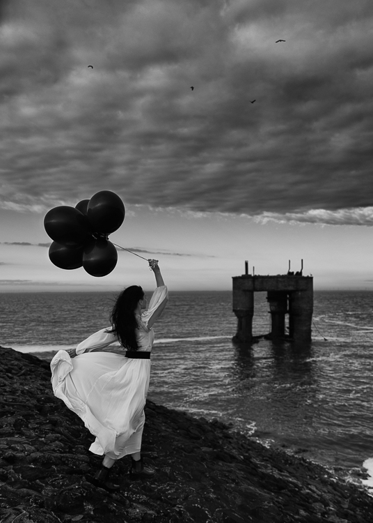 Artwork Editorial Frau weißes Kleid schwarze Luftballons Nordsee Butjadingen dramatischer Himmel, professioneller Portraitfotograf Mario Diener