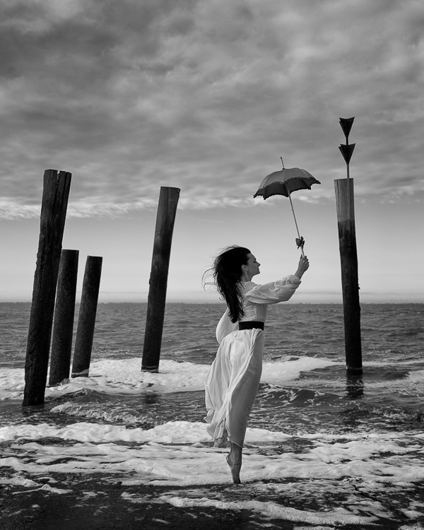 Artwork Editorial Frau weißes Kleid Regenschirm Nordsee Butjadingen stimmungsvolle Landschaft, professioneller Portraitfotograf Escborn
