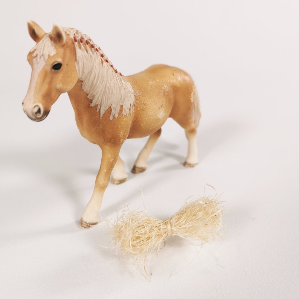 Strohbündel vor einem Schleich® Pferd