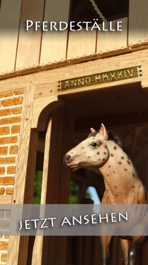 Holzstall von 3zinken.de mit einem Schleich Pferd im Tor des großen Pferdestalls.