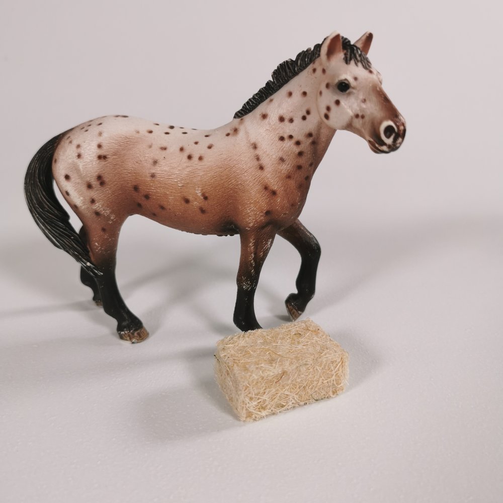 Schleich® Pferd hinter einem Strohballen im Maßstab 1:24