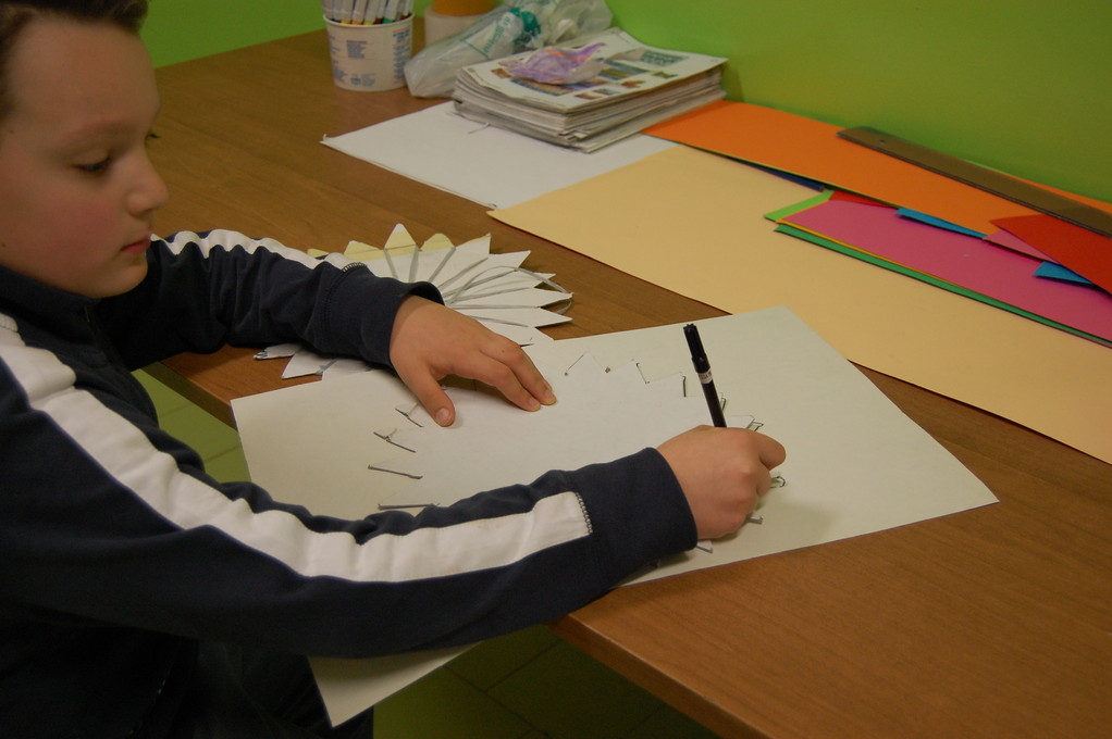 ABBIAMO DISEGNATO LA SAGOMA DI CARTONCINO A 21 PUNTE CHE SERVIVA PER INTRECCIARE I FILI DI RAFIA...