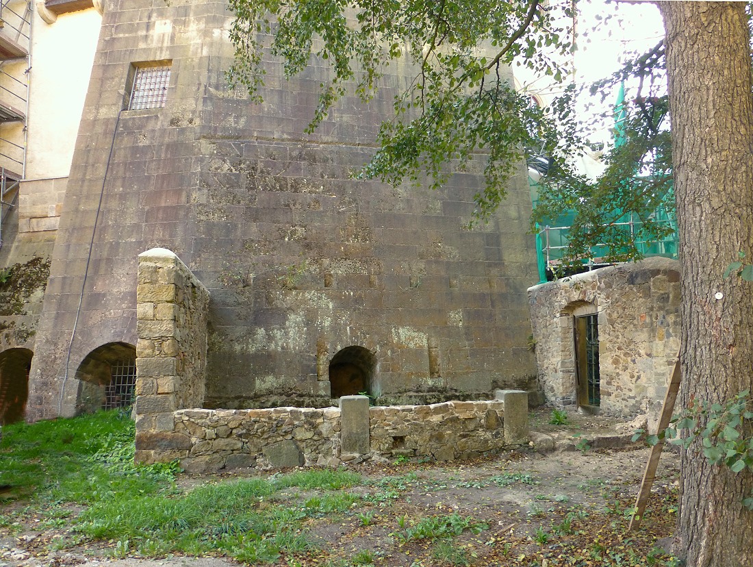 Die gewaltige nordwestliche Stützmauer der Hauptburg, direkt auf den Fels gesetzt.  Ansicht vom Schlossgarten aus. Rechts die Außenmauer des Gefängnishofes.