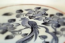 白地に墨絵のように椿と尾長鳥を描いた、すくい織の帯です。