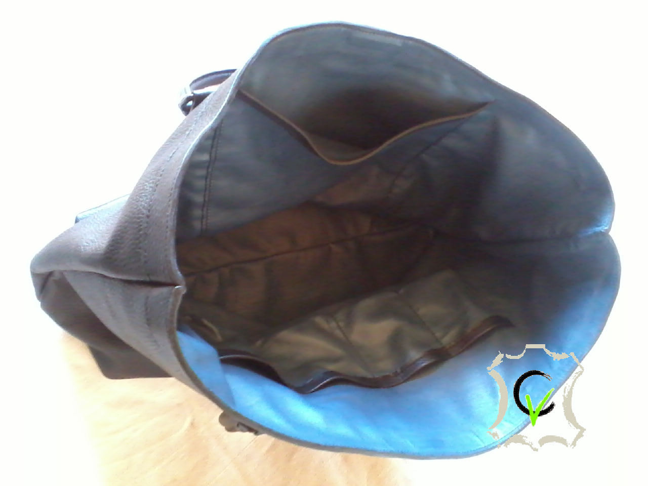 Sac à main en cuir vachette noir grainé. fermeture centrale par aimants, douyblé cuir mouton bleu, une poche, quatre pochettes et une pochette porte stylo