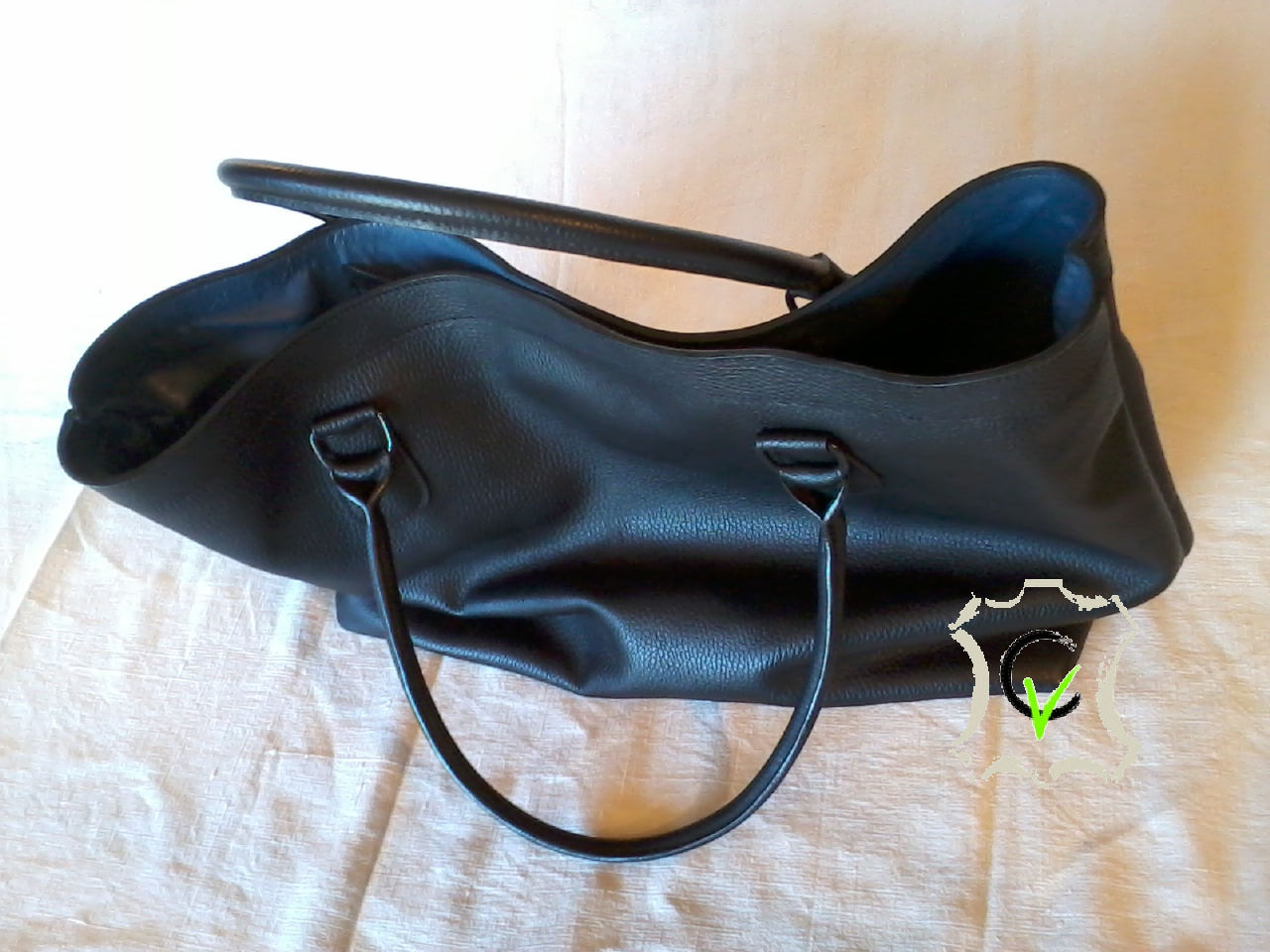 Sac à main en cuir vachette noir grainé. fermeture centrale par aimants, douyblé cuir mouton bleu, une poche, quatre pochettes et une pochette porte stylo