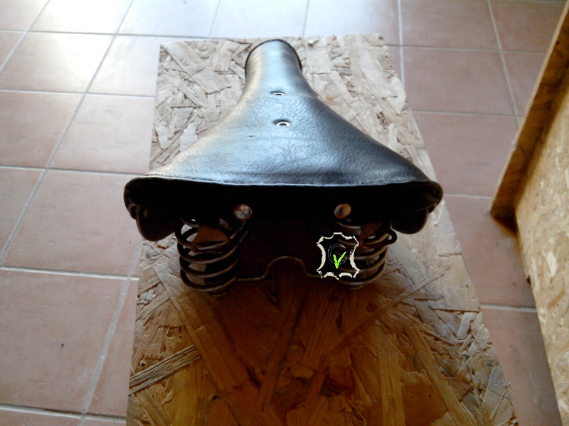 selle de vélo en cuir tendu sur une arature métallique