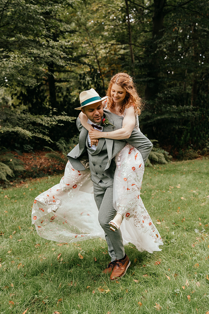 bruid springt op de rug van de bruidegom en ze wandelen zo verder-huwelijksfotografie-trouwreportage-byFotografils-IlseWagemakers-Fotograaf gevestigd in Essen