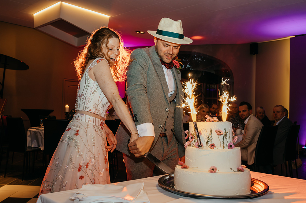 bruid en bruidegom snijden de huwelijkstaart aan-huwelijksfotografie-trouwreportage-byFotografils-IlseWagemakers-Fotograaf gevestigd in Essen