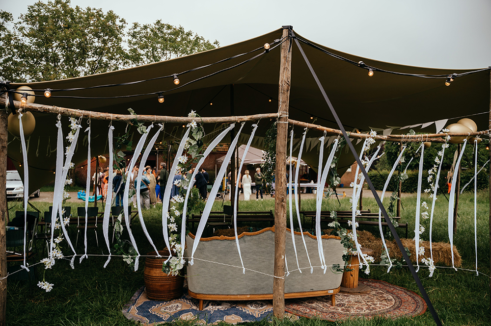 sfeerfoto van de ceremonietent, waarbij de wind speelt doorheen de linten-huwelijksfotografie-trouwreportage-byFotografils-IlseWagemakers-Fotograaf gevestigd in Essen