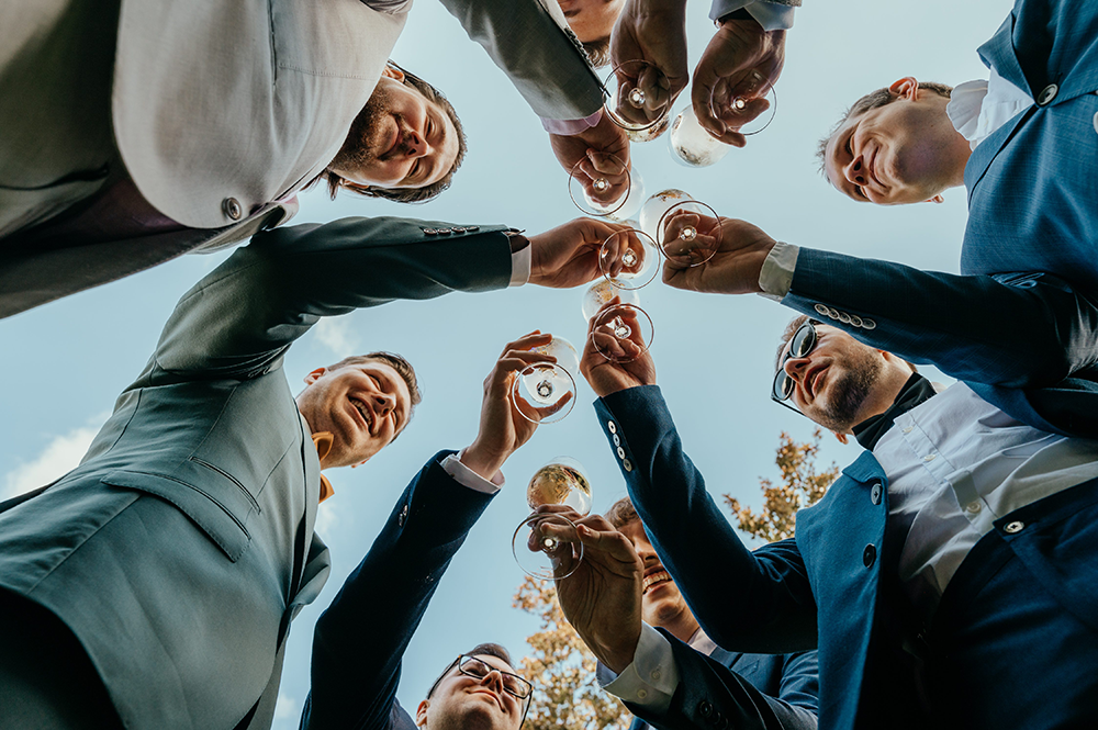 proostende mannen, foto genomen vanuit kikvorsperspectief-huwelijksfotografie-trouwreportage-byFotografils-IlseWagemakers-Fotograaf gevestigd in Essen